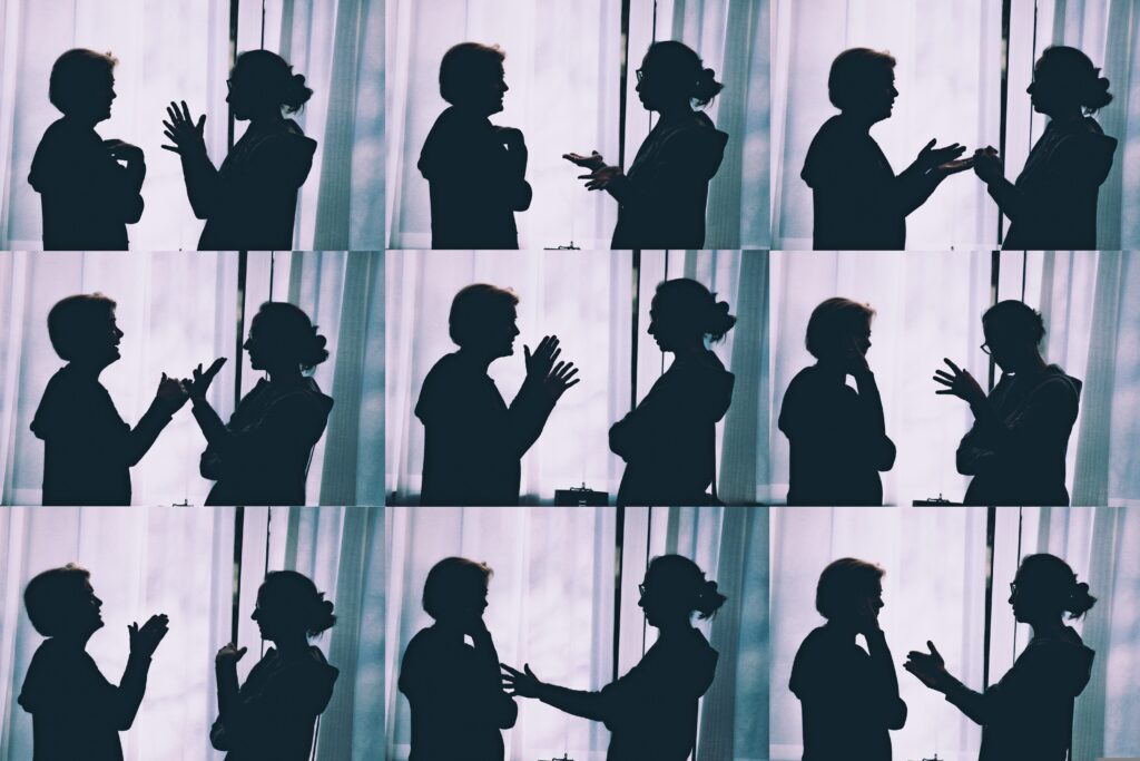 The image shows two people engaging in conversation in IELTS speaking while identifying and rectifying their errors through self-correction